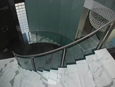 curved glass banister marble stairs